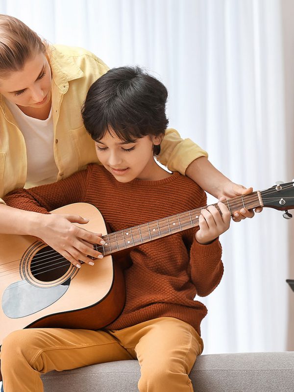 Private music teacher giving guitar lessons